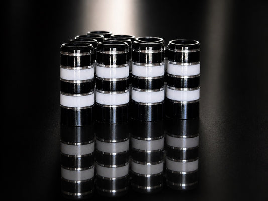 A pack of ten Classy Jailbird ferrules: glossy black with white bands and polished silver pinstripes, standing on a mirrored black surface.