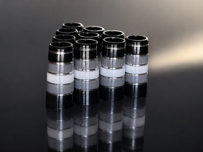 A pack of ten Gray Thunder ferrules: black and smoke gray with white bands and polished silver pinstripes, standing on a mirrored black surface.